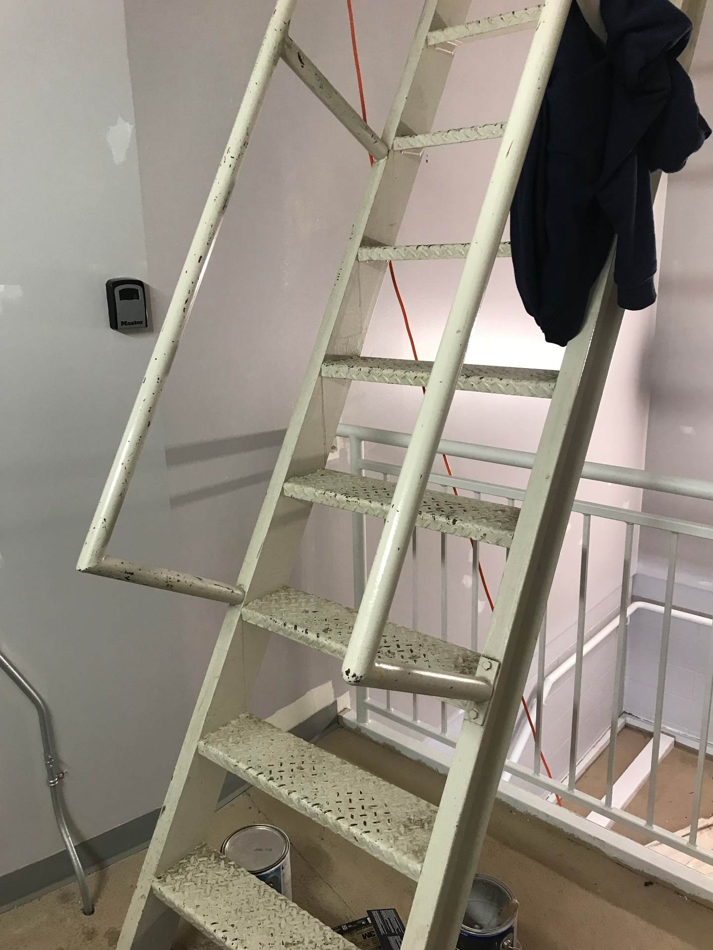 Commercial stairwell during painting work with ladder and equipment